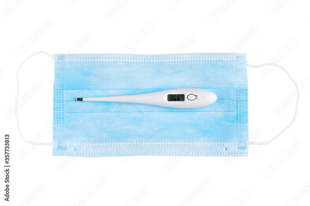 Electronic thermometer on blue medical face mask. Isolated on white background. Electronic thermometer on blue medical face mask. Isolated on white background.