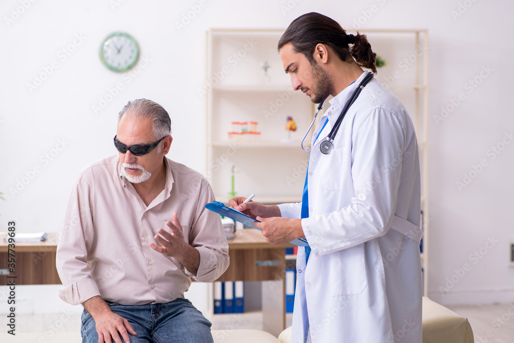 Old blind man visiting young male doctor Old blind man visiting young male doctor
