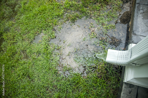 Фотография Hard rainwater pouring out of getters and a drain spout after a day of heavy rai