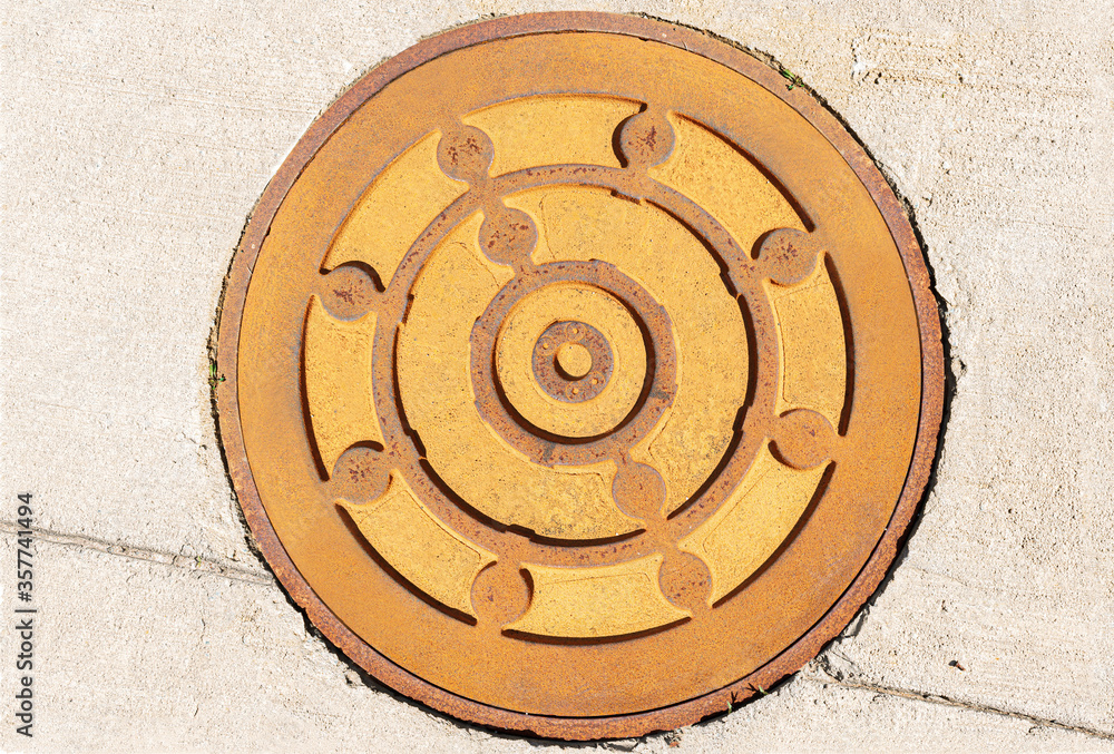 Rusty metal manhole texture on concrete background