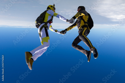 Two sports parachutist build a figure in free fall. Extreme sport concept. © German Skydiver