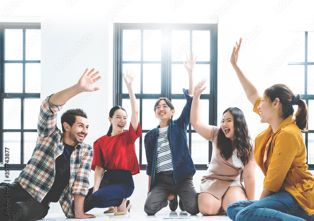 Cheerful asian male and female students celebrating winning in college contest giving high five, emotional multiracial members of crew excited with success in productive working process on startup - obrazy, fototapety, plakaty 