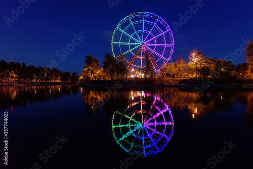 Russia, Irkutsk - June 13, 2020: Colorfull abstract Ferris wheel with reflection on the Konny island in Irkutsk city