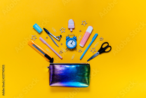 Back to school concept notepad, pencil case, stationery and school supplies. Top horizontal view copyspace yellow abstract background