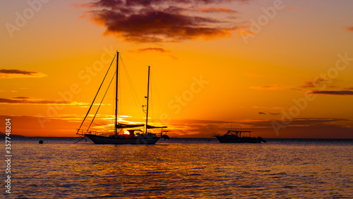 yellow and orange sunset with a sailboat silhouette