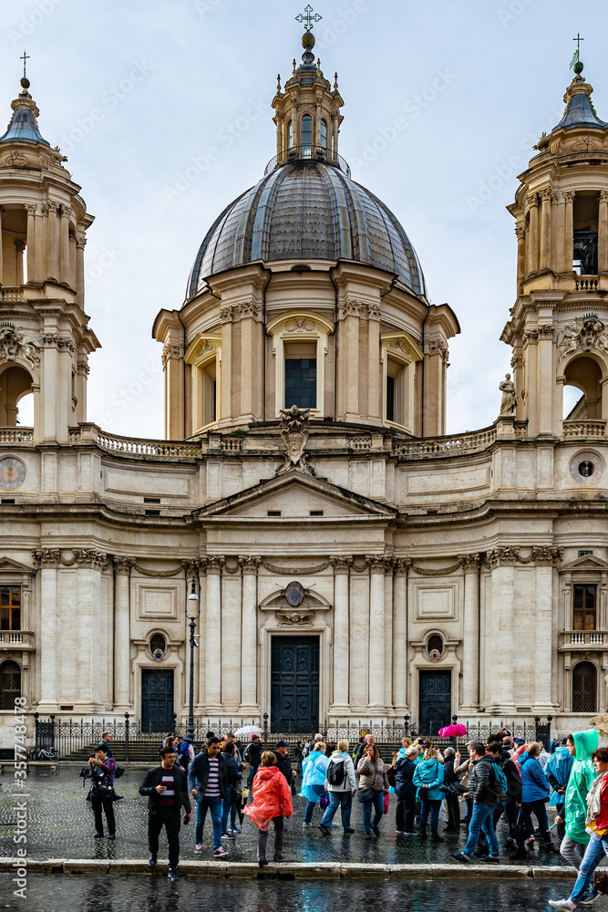 People/ Tourists crowd in front Sant'Agnese in Agone (Sant'Agnese in Piazza Navona) a vintage 17th century Baroque Church in the city which faces unto the Piazza Navona in Rome, Italy.