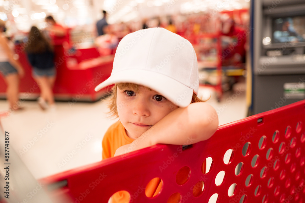 Funny kids shopping. Joyful beautiful child boy in supermarket buys vegetables. Healthy food for children. Funny kids shopping. Joyful beautiful child boy in supermarket buys vegetables. Healthy food for children.
