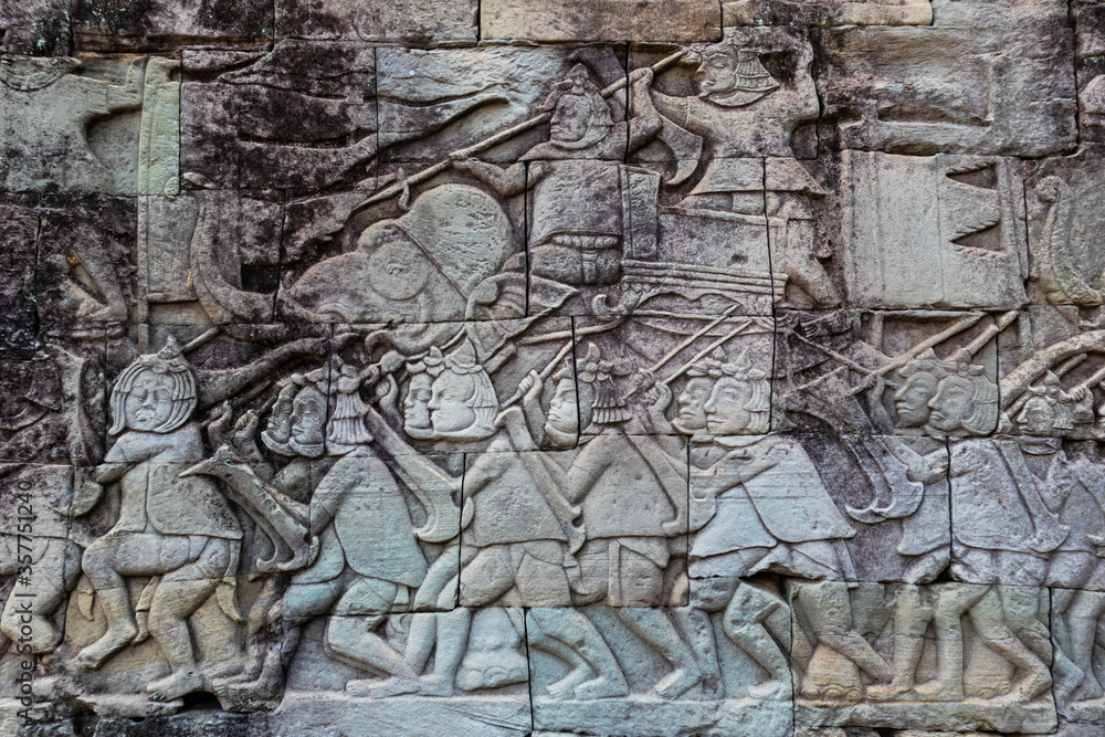 Elephants and marching soldiers of the khmer army carved on a wall of a gallery at Bayon temple at the center of Angkor Thom complex in Siem Reap, Cambodia, South east Asia