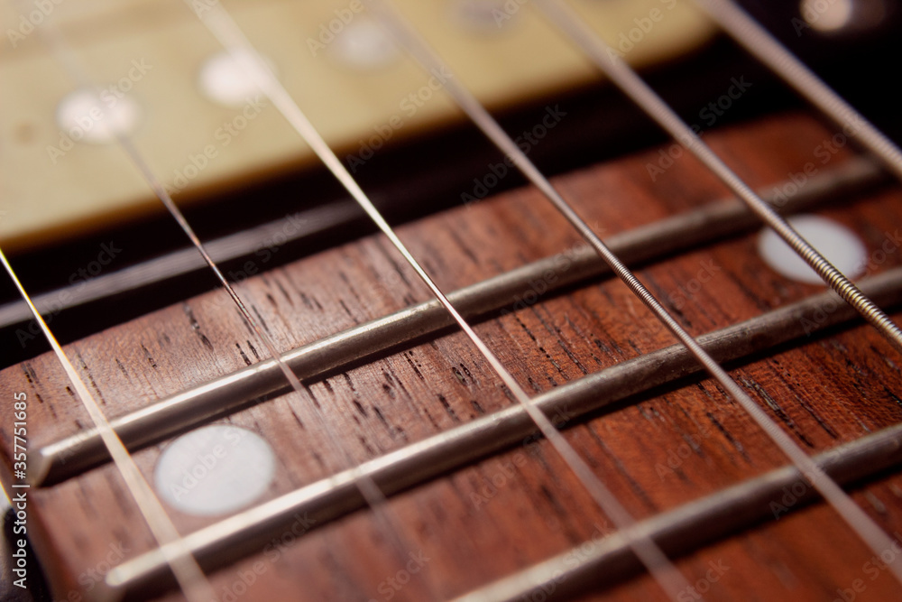 Macro photography to a six electric guitar strings and wooden fretboards. Vintage instruments and music concept Macro photography to a six electric guitar strings and wooden fretboards. Vintage instruments and music concept
