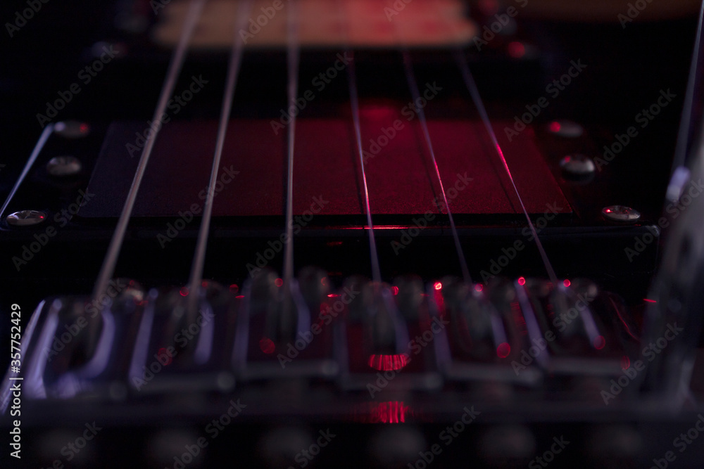 closeup to a six black electric guitar strings and microphones . Instruments and music concept closeup to a six black electric guitar strings and microphones . Instruments and music concept