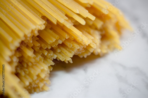Yellow long spaghetti on a rustic background. Yellow italian pasta. Long spaghetti. Raw spaghetti bolognese. Raw spaghetti. Food background concept. Italian food and menu concept.