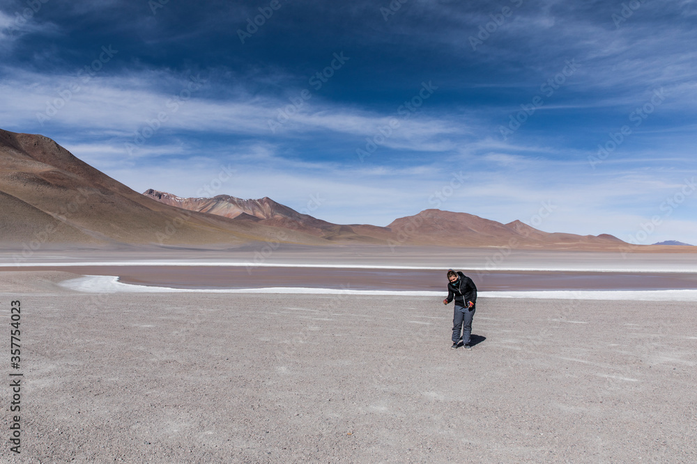 Young woman standing on desert and red lake