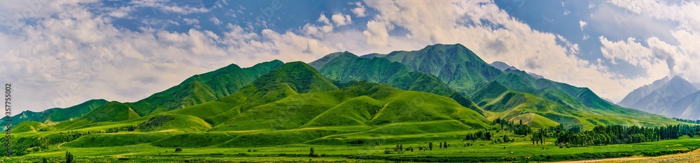 Panorama of a mountain valley in the summer. A fabulous mountain view of the peaks, amazing nature, summer in the mountains. Travel, tourism. beautiful background picture of nature
