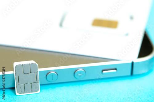 nano SIM card and smartphone on a blue background photo