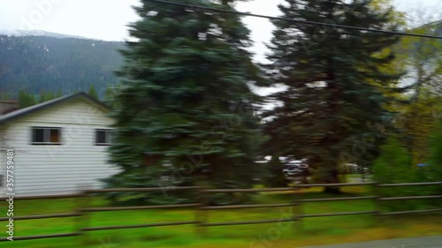 Panning shot of structures and vehicles by trees near mountains against sky - Cheakamus Lake, British Columbia photo