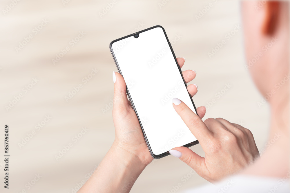 Mockup image of woman's hands holding mobile phone with blank screen, indoor