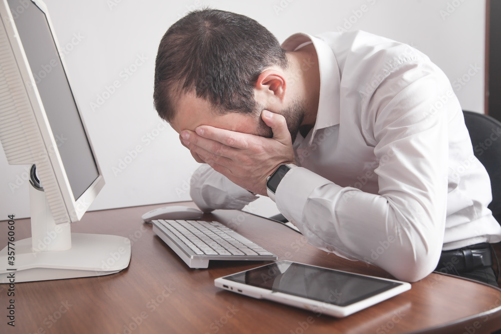 Caucasian stressed businessman sitting in office. Caucasian stressed businessman sitting in office.