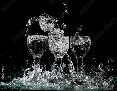 glasses with water with splashes on a black background