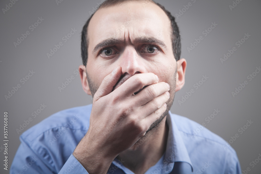 Shocked caucasian man covering his mouth with hand. Shocked caucasian man covering his mouth with hand.
