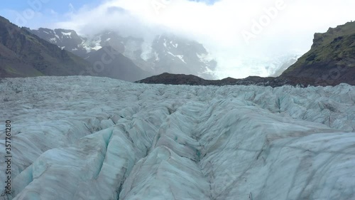 Glacier Svinafellsjokul in Southern Iceland, drone flying Glacier of beautiful unique turquoise color on background of snow in Arctic photo