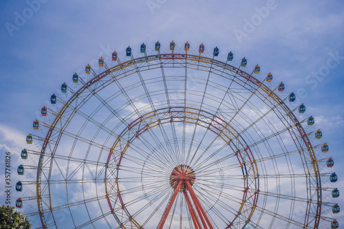 A ferris wheel with colorful cabins at a local fun fair