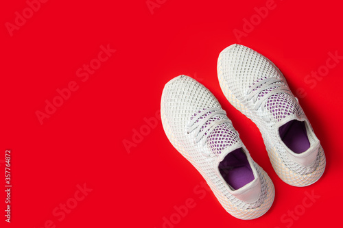 Sports sneakers on a red background. Concept of sport, fashion. Top view, flat lay