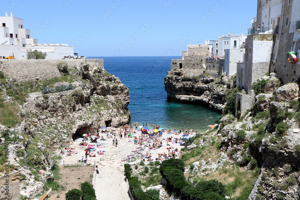 Bathers and tourists in the famous Lama Monachile beach in Polignano a Mare, Puglia, Italy