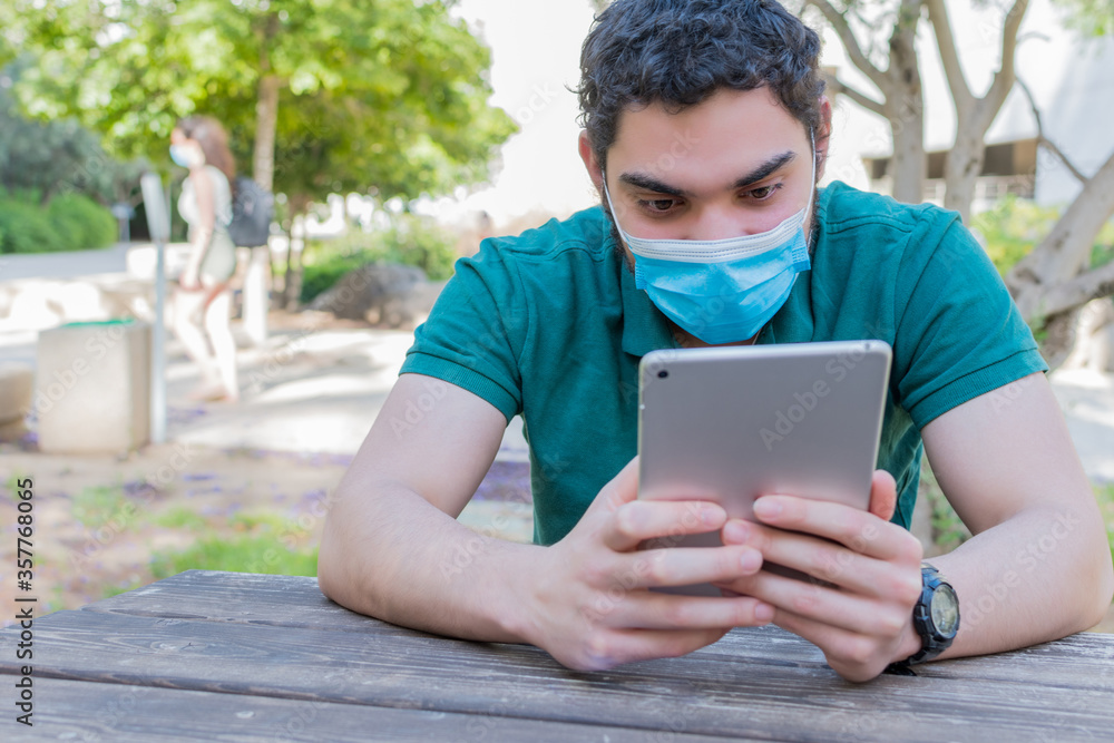 A serious guy watching online media on a tablet A serious guy watching online media on a tablet