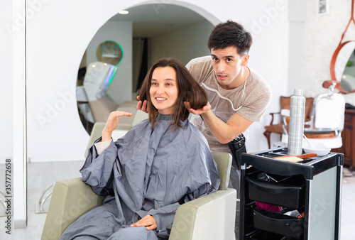 Happy young woman and hairdresser after haircut