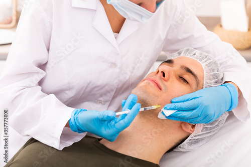 Man receiving facial contouring injections