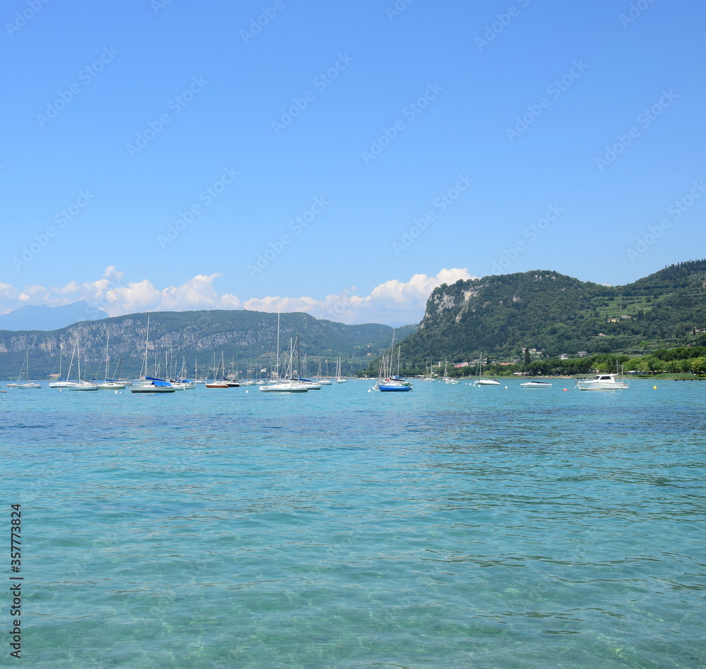 Bardolino am Gardasee in Italien - Küstenabschnitt mit Booten und türkisblauen Wasser
