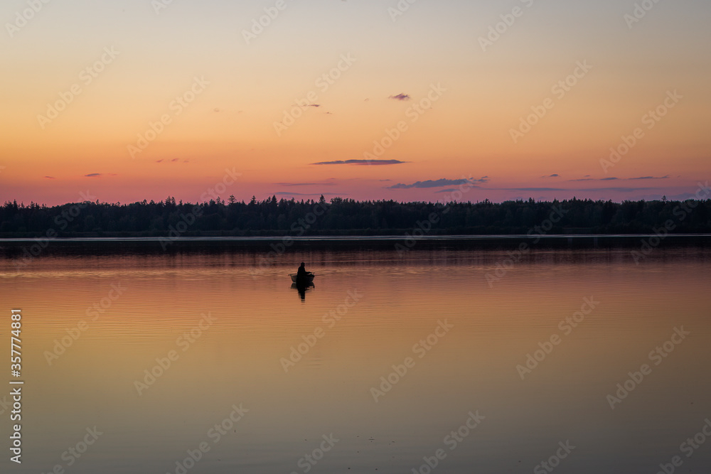 Fishermen in a rowing boat on the lake at sunset Fishermen in a rowing boat on the lake at sunset