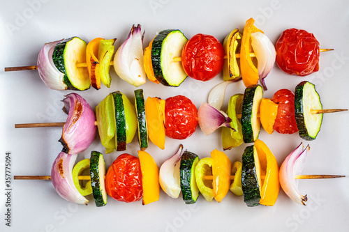 Grilled skewers vegetables on gray rectangular plate. Vegan food concept. photo