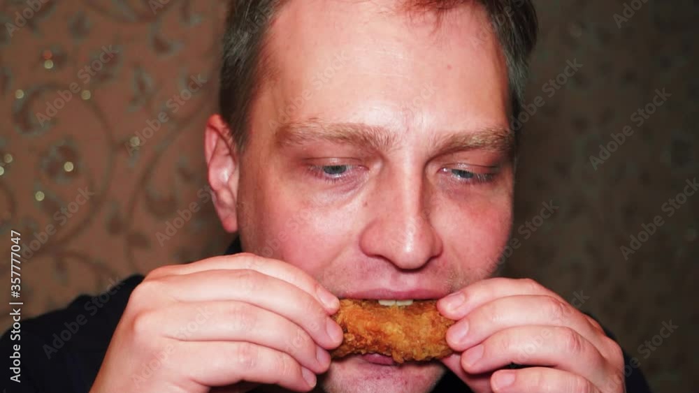A man eats a delicious fried chicken A man eats a delicious fried chicken