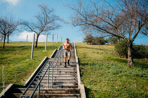 Young man running upstairs training outdoor - Man athlete jogging moving up stairs