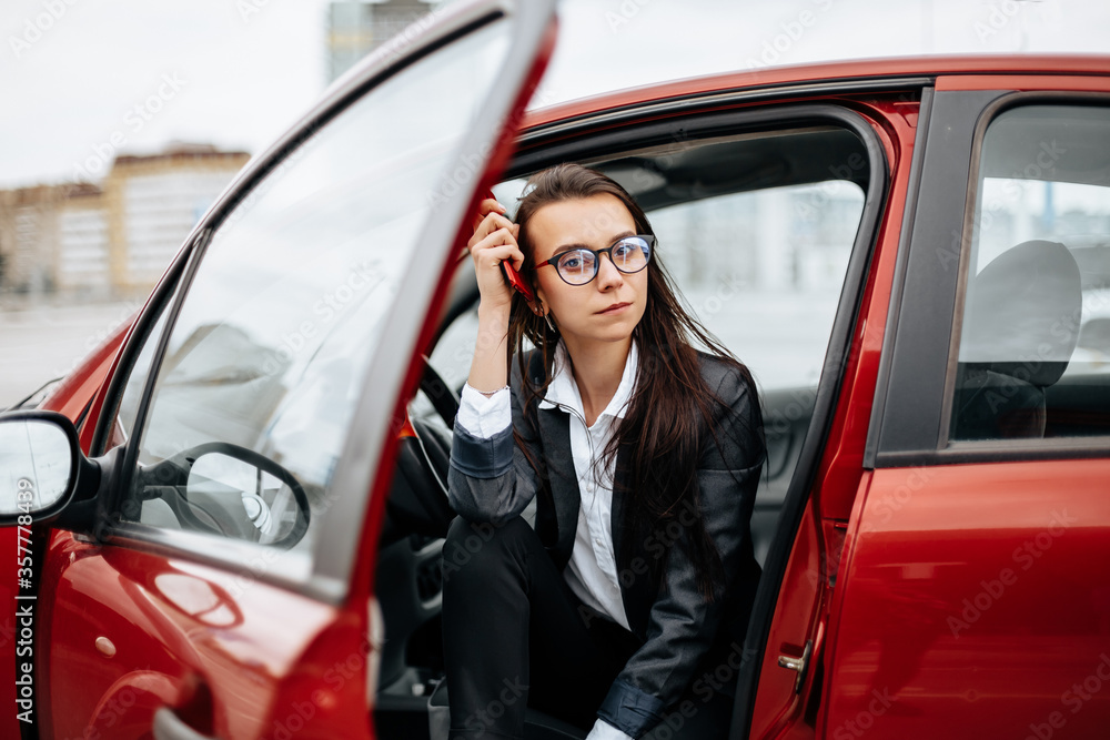 The girl in the car. A woman in a parking lot sits in a auto. The girl in the car. A woman in a parking lot sits in a auto.