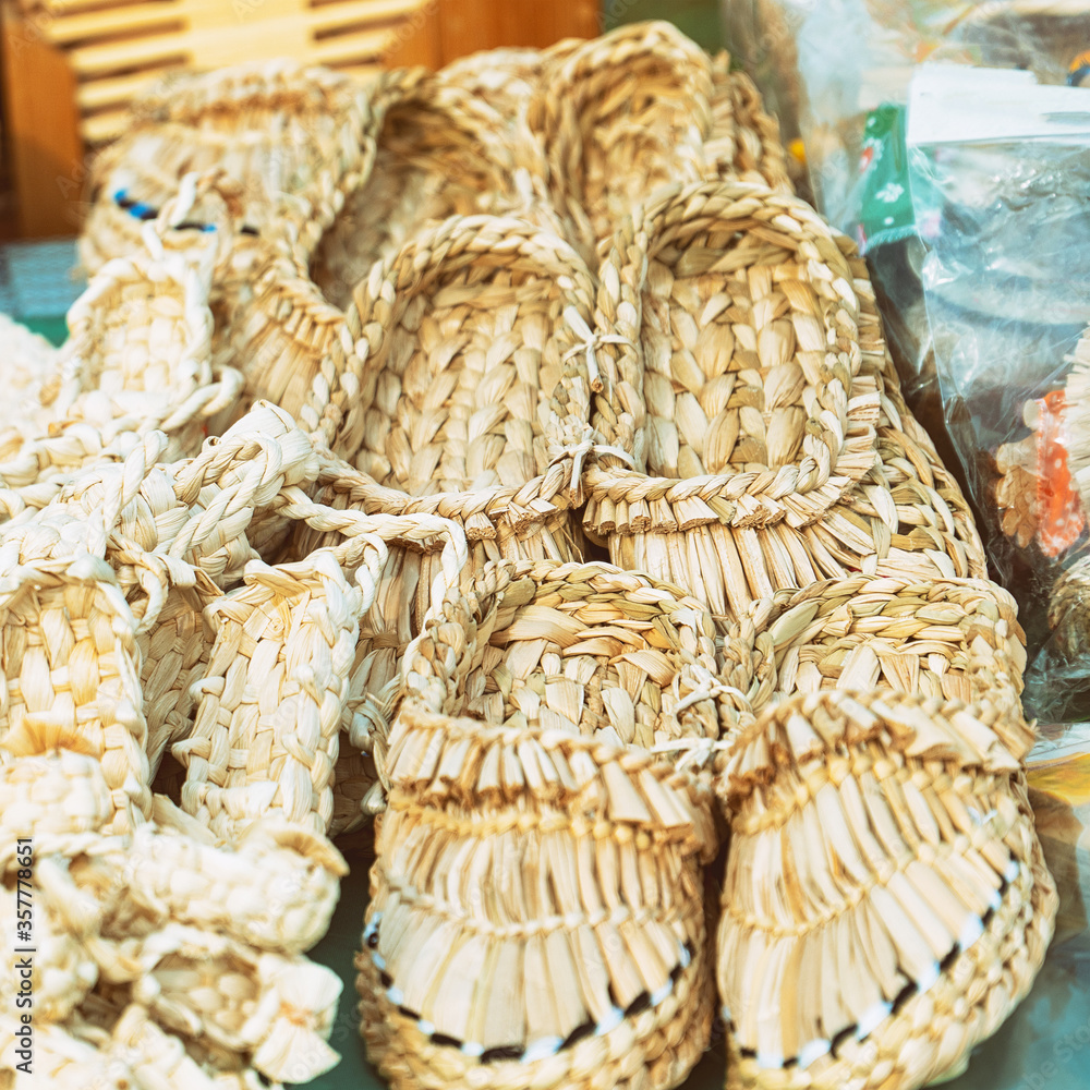 Souvenir bast shoes woven from bast. Old traditional Russian shoes