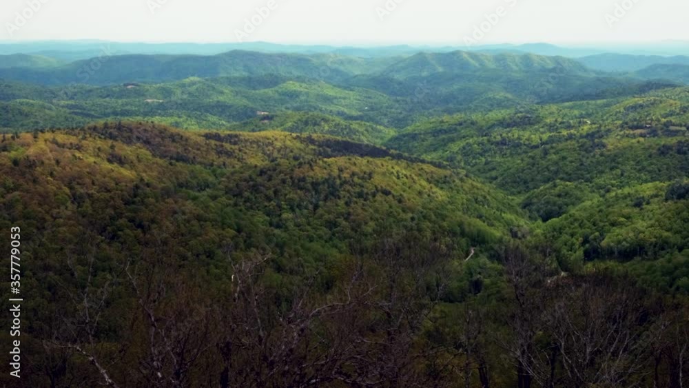 Wonderful shades and hues of springtime green in distant mountain ranges and valleys in vast countryside, handheld pan right Wonderful shades and hues of springtime green in distant mountain ranges and valleys in vast countryside, handheld pan right