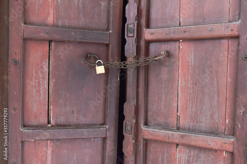 old rusty wooden door with a golden lock 