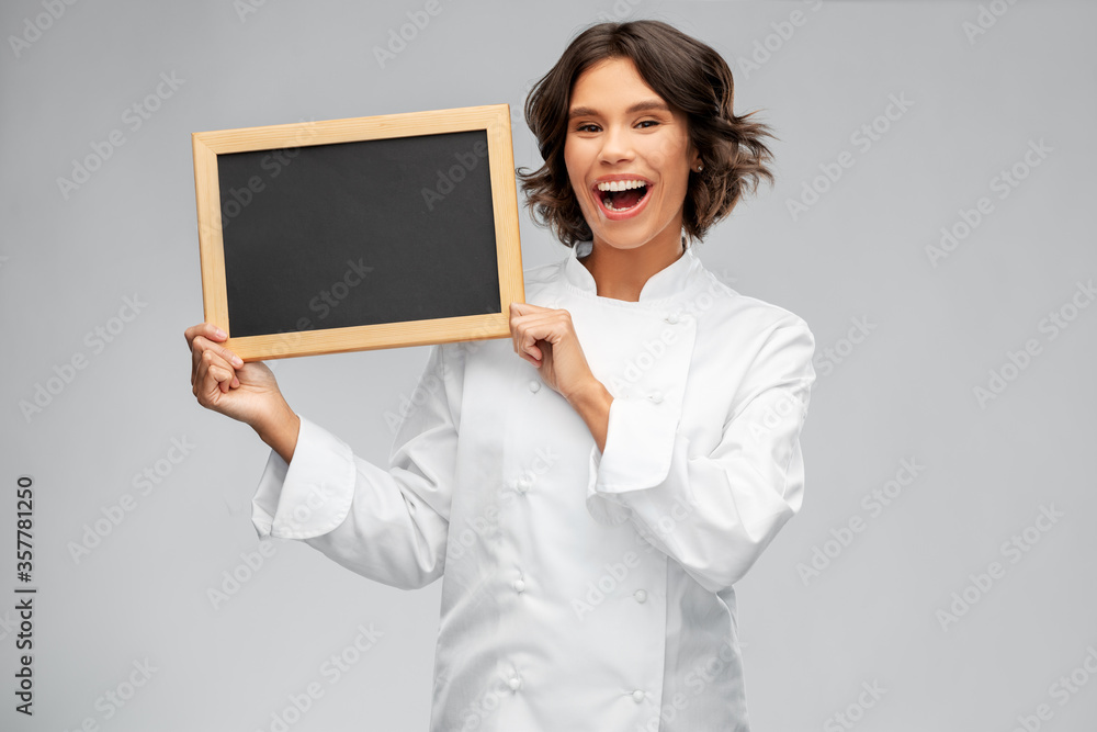 cooking, advertisement and people concept - happy smiling female chef holding black chalkboard over grey background cooking, advertisement and people concept - happy smiling female chef holding black chalkboard over grey background