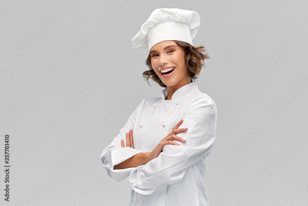 cooking, culinary and people concept - happy smiling female chef in toque with crossed arms over grey background cooking, culinary and people concept - happy smiling female chef in toque with crossed arms over grey background
