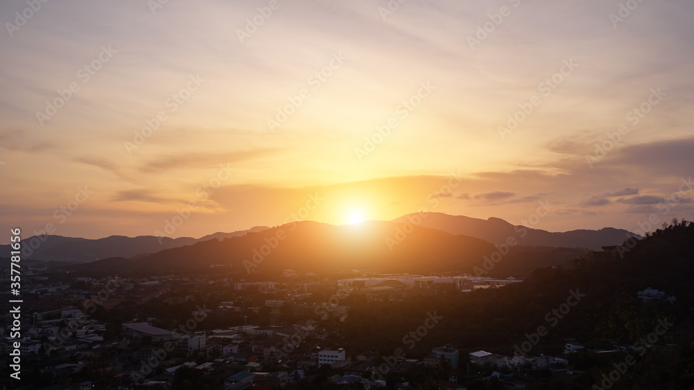 sunrise goes into sunset over hills surrounding valley with small town and forests in tropical country timelapse