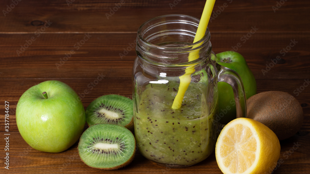 Blended green smoothie with kiwi and green apple on wooden background