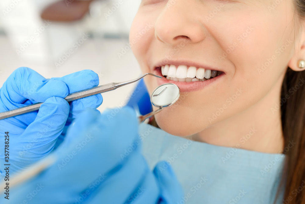Dentist hands with dental instruments examination patient's teeth in medical clinic Dentist hands with dental instruments examination patient's teeth in medical clinic