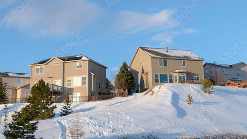 Panorama Wasatch Mountains landscape with houses evergreens amid snowy terrain in winter