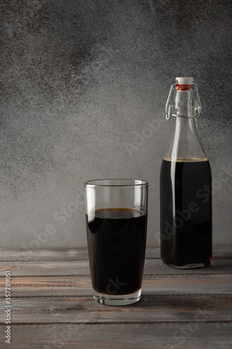 Dark brown bottle with a bugle plug of homemade kvass and glass. Wonderful healthy refreshing drink for summer