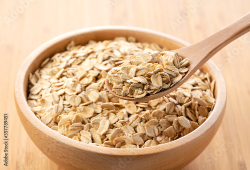 Oatmeal and wooden spoon set against a wooden background