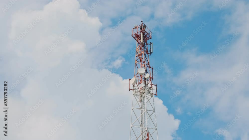 Cell tower antennas 3G, 4G или 5G on a background of blue sky with moving clouds, timelapse. Cell tower antennas 3G, 4G или 5G on a background of blue sky with moving clouds, timelapse.