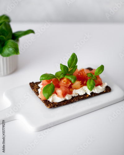 Open sandwiches with cream cheese, cherry tomatoes and basil