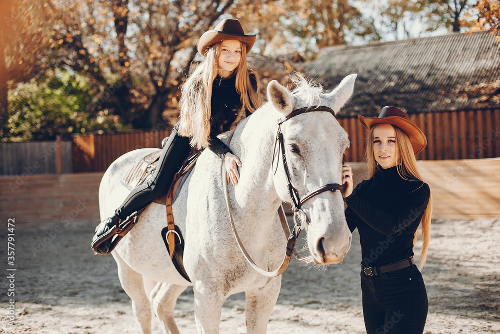 Fototapeta premium Girls with a horse. Women in a ranch. Blonde in a black sweater